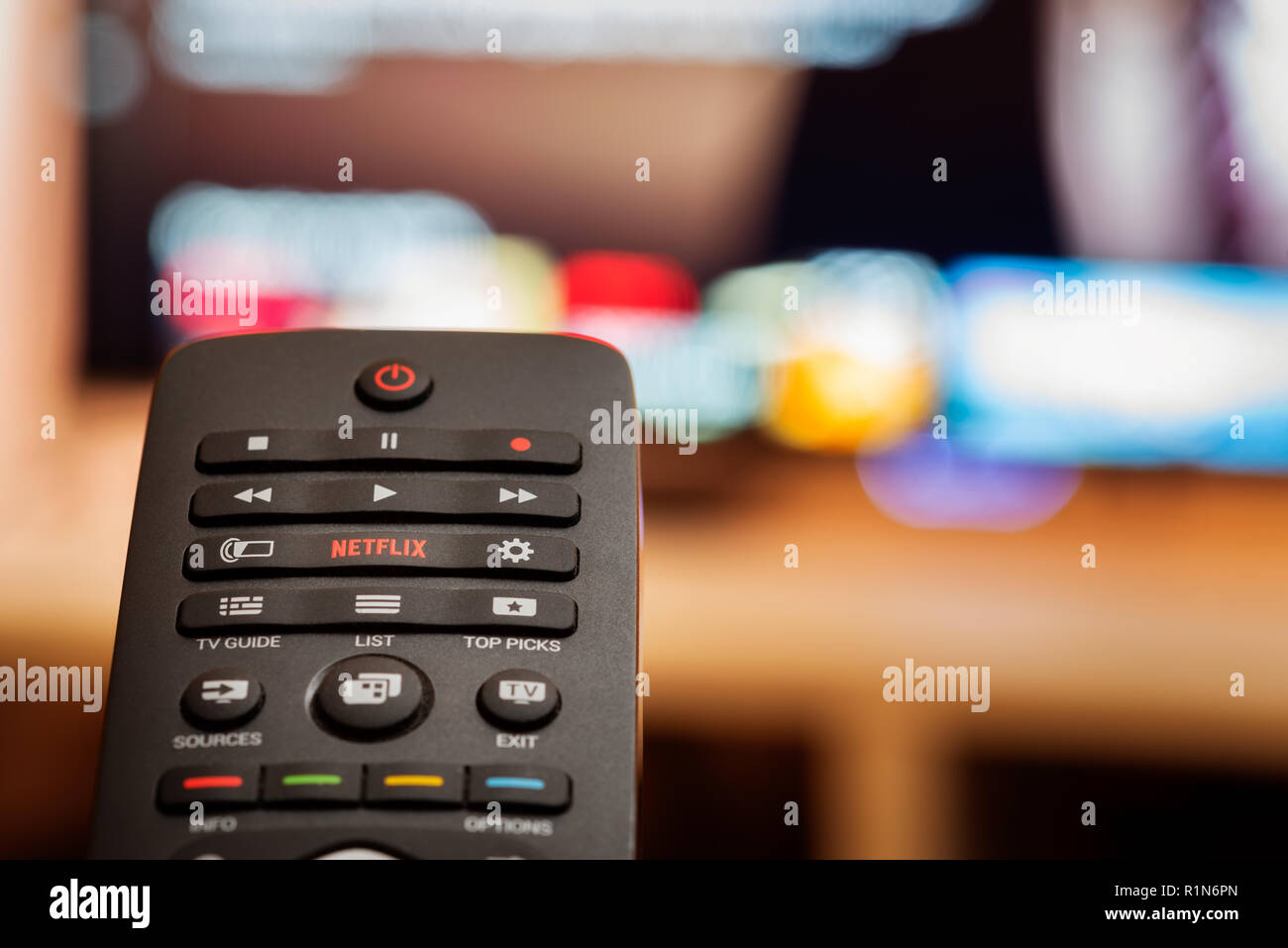 TV Remote avec bouton Netflix dédié en face de Smart TV de flou artistique Banque D'Images