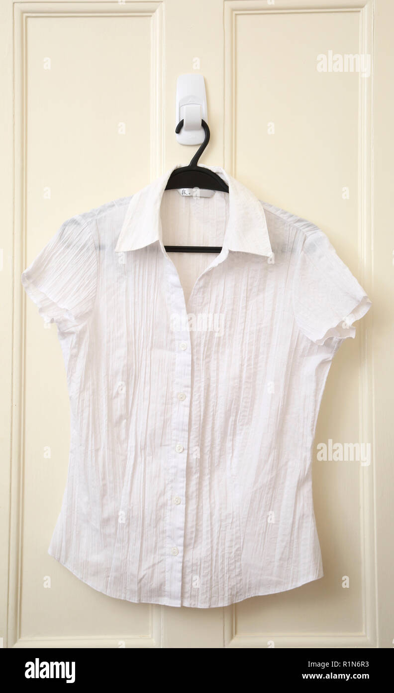 Chemise en coton blanc accroché sur la porte Photo Stock - Alamy
