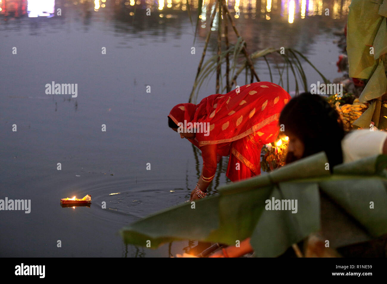 Un dévot népalais vus offrant des prières pour le coucher de soleil dans l'eau pendant l'Chhath Puja festival. Le Chhath Festival, également connu sous le nom de Surya Pooja, ou le culte du soleil, est observée dans les régions de l'Inde et le Népal comme dévots rendent hommage au soleil et l'eau des dieux. Banque D'Images