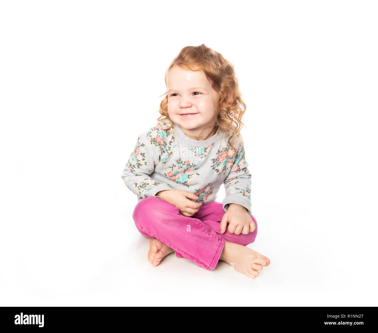 Une jolie petite fille rousse en studio avec fond blanc Banque D'Images