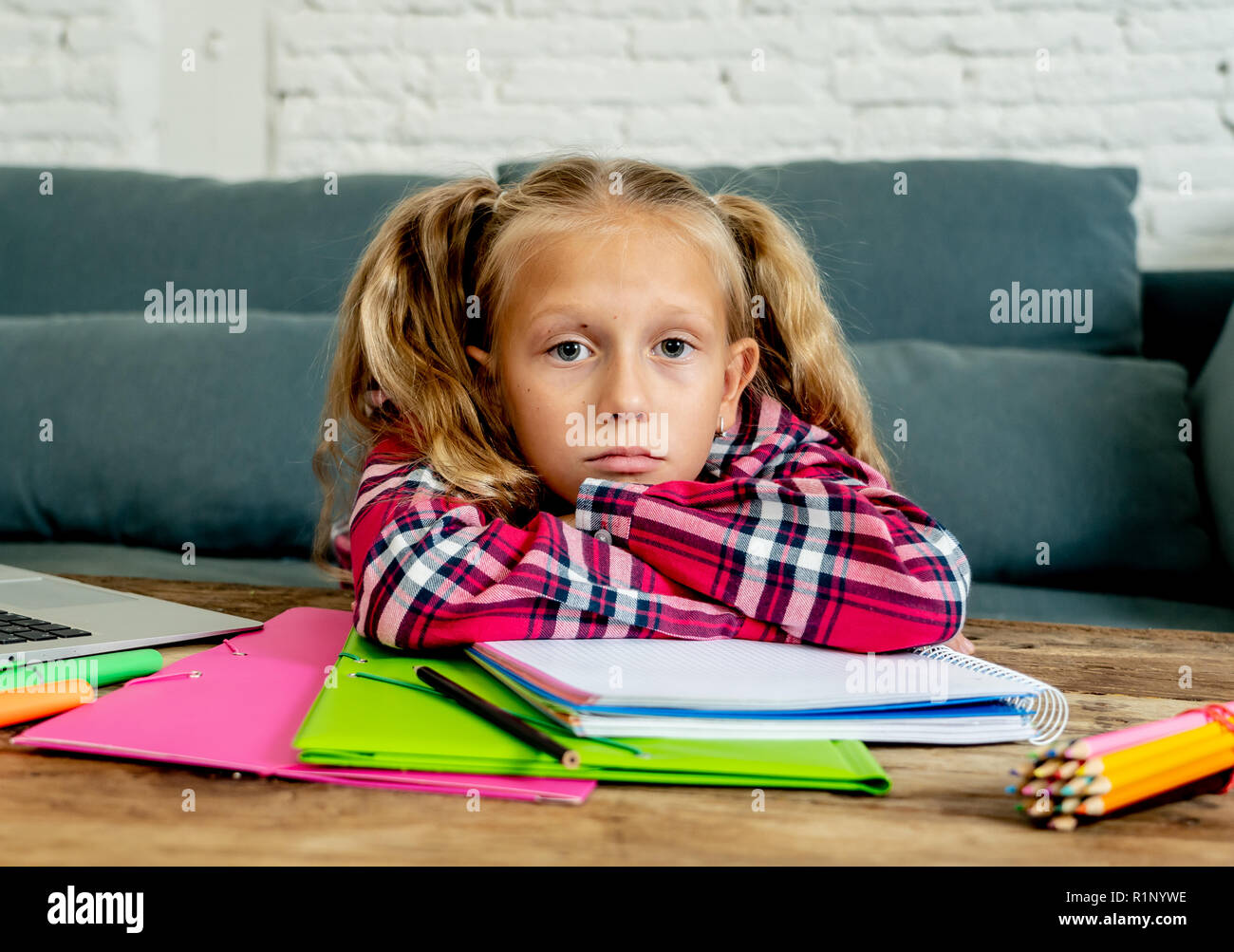 Cute blonde magnifique 9 ans élève d'école élémentaire se sentir triste ennuie et la submergés essayant d'étudier à la maison dans des difficultés d'apprentissage une devoirs examens Banque D'Images