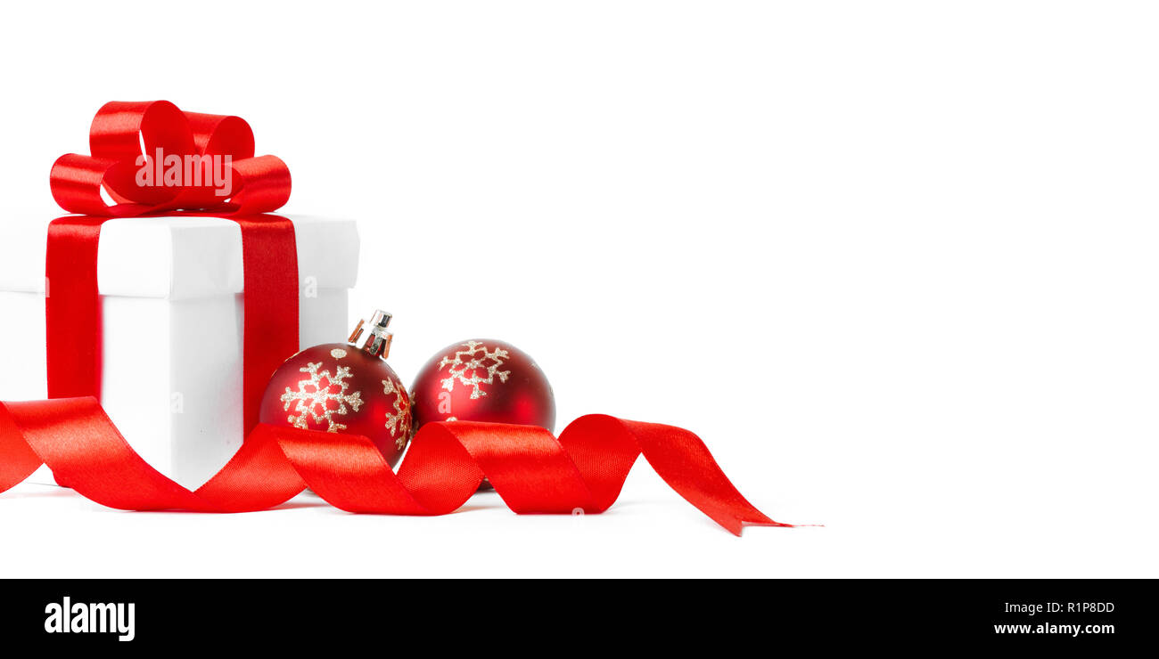 Cadeau de Noël avec des boules rouges arc isolé sur fond blanc Banque D'Images