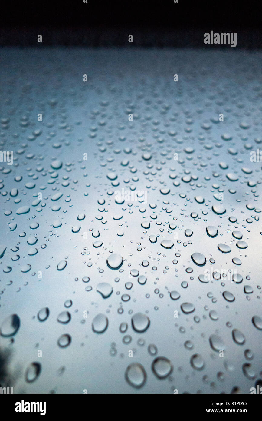 Gouttes de pluie sur fenêtre contre ciel sombre sombre Banque D'Images