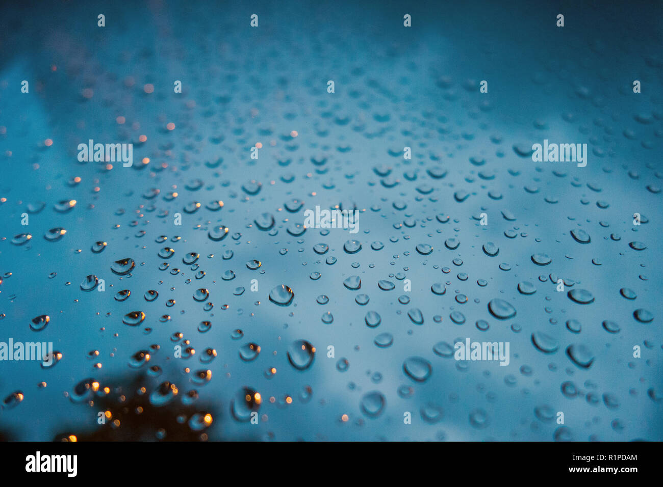 Gros plan très photographie de gouttes de pluie sur la fenêtre en verre avec ciel sombre à l'arrière-plan Banque D'Images