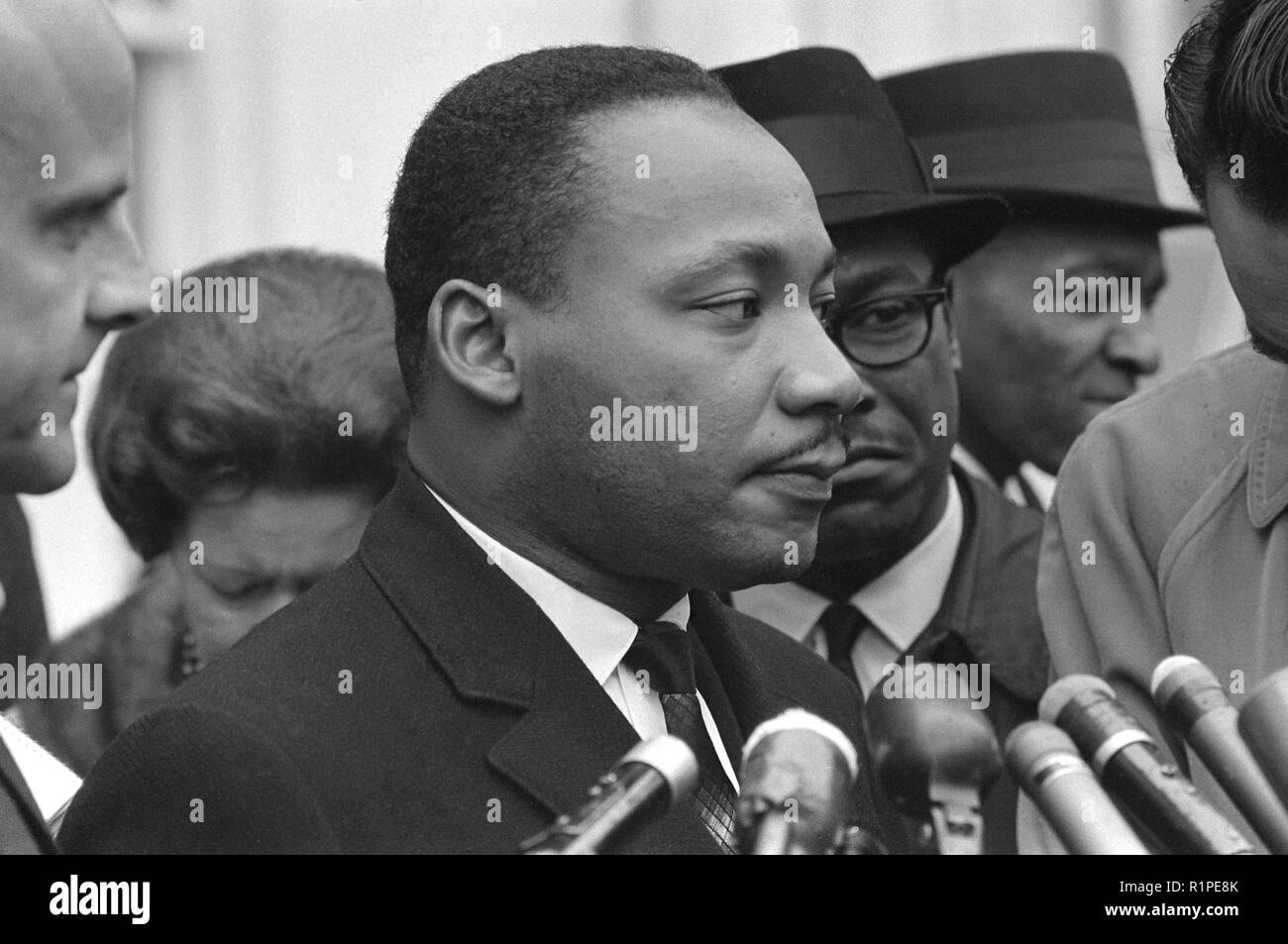 Martin Luther King, Jr., tête-et-épaules portrait, faisant face à droite, à micros, après une rencontre avec le président Johnson pour discuter des droits civils, à la Maison Blanche, 1963 Banque D'Images