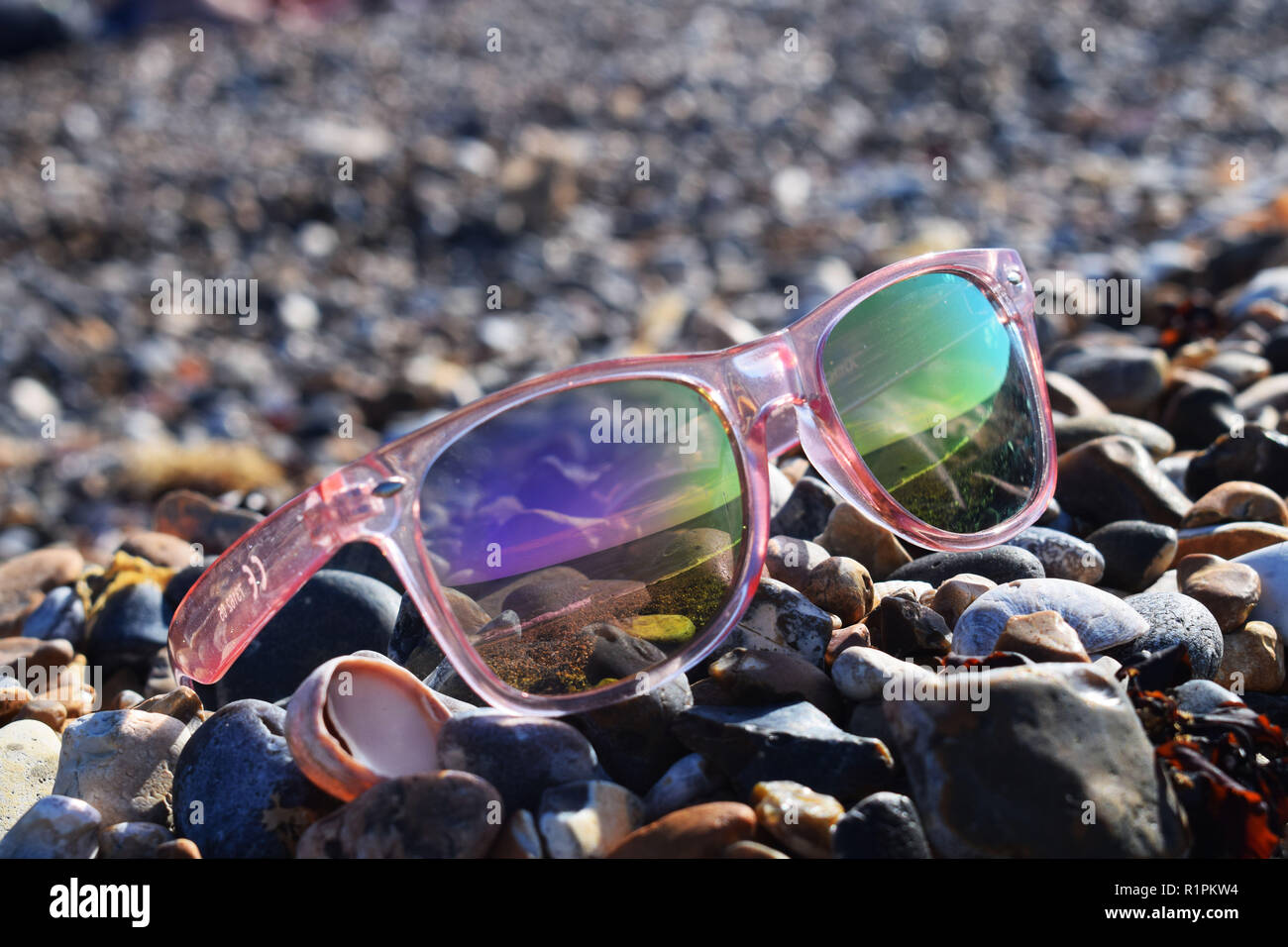 Une belle vue sur l'océan à travers une paire de lunettes de couleur rose au milieu du mois d'août Banque D'Images