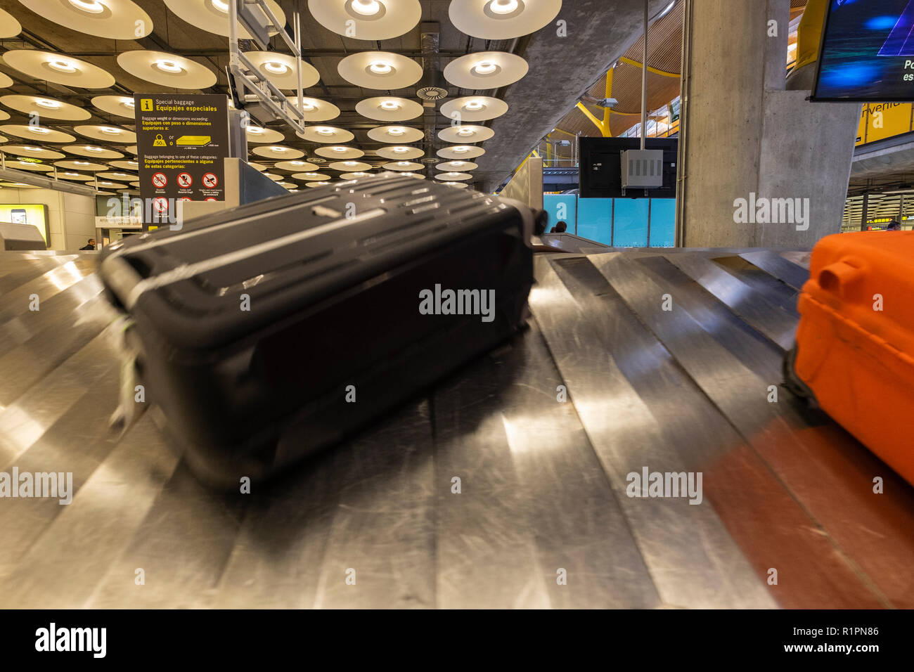 Valises sur le tapis roulant qui arrivent dans la zone de récupération des bagages dans le hall des arrivées du Adolfo Suares aéroport Barajas de Madrid, Espagne Banque D'Images