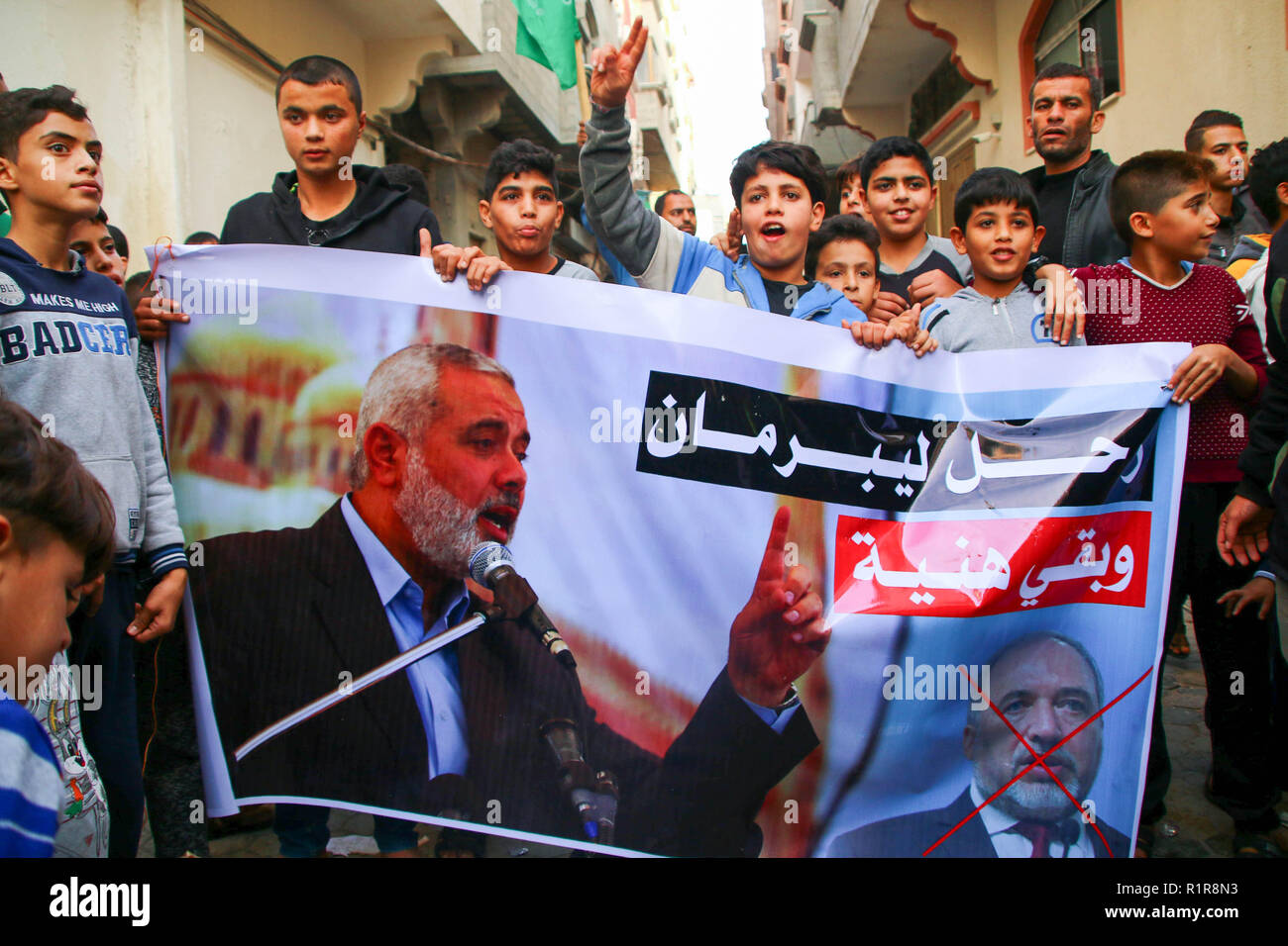 Des manifestants palestiniens tenant une bannière à l'appui de la gouvernement du Hamas en face de la maison d'Ismail Haniyeh, chef du peuple palestinien Hamas à Gaza. Des centaines de Palestiniens de Gaza se sont rassemblés devant la maison du chef du Hamas Ismail Haniyeh pour manifester leur appui au gouvernement du Hamas et protester contre la décision de l'attaque aérienne faite par le ministre de la défense Israélien Avigdor Lieberman qui a causé des dommages à l'infrastructure à grande échelle et de décès de civils. Banque D'Images