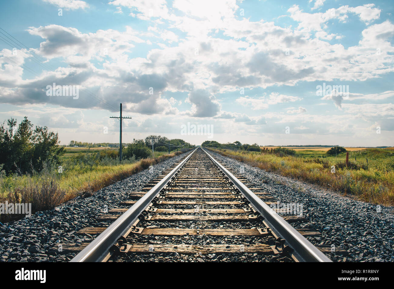 Photo de paysage des lignes de chemin de fer menant contre ciel nuageux ciel bleu Banque D'Images