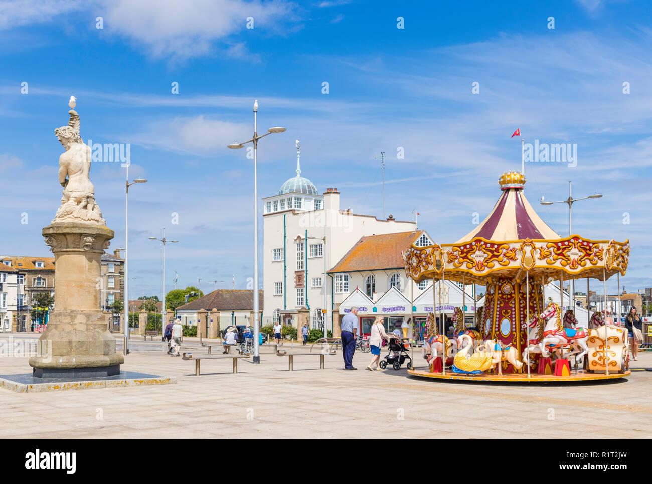 Lowestoft fairground carousel et Tritin statue près de Royal Norfolk et Suffolk Royal Yacht Club de mer ordinaire Lowestoft Suffolk Angleterre UK GO Europe Banque D'Images