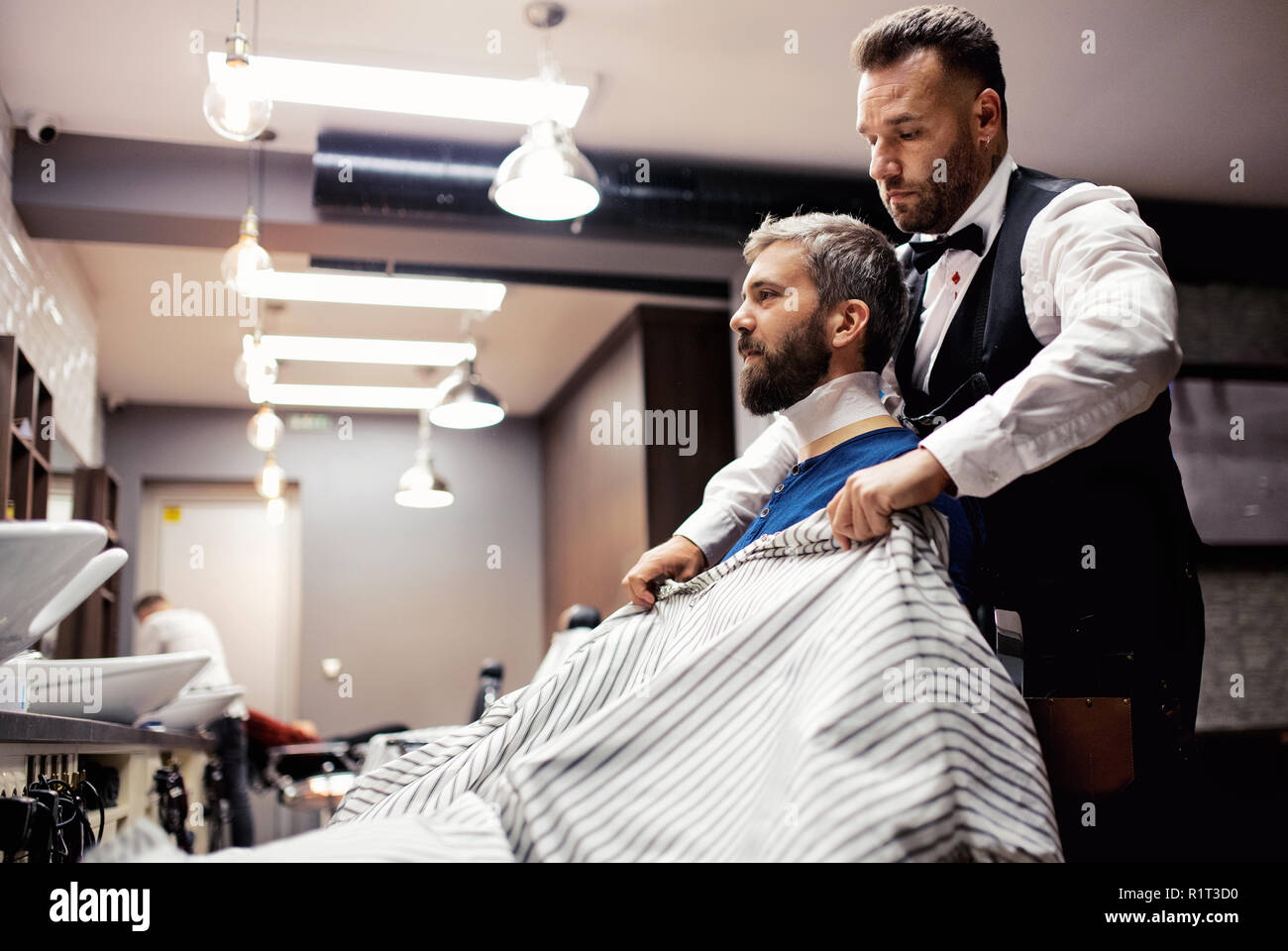 Offres et demandes de visite client homme Hipster et hairstylist dans barber shop. Banque D'Images