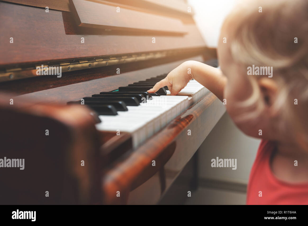 L'éducation musicale - enfant poussant les touches de piano Banque D'Images