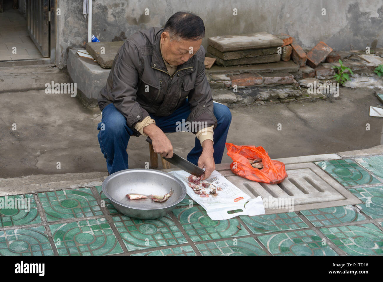 L'homme chinois la préparation d'un repas de poisson dans Zingzhou Chine Banque D'Images