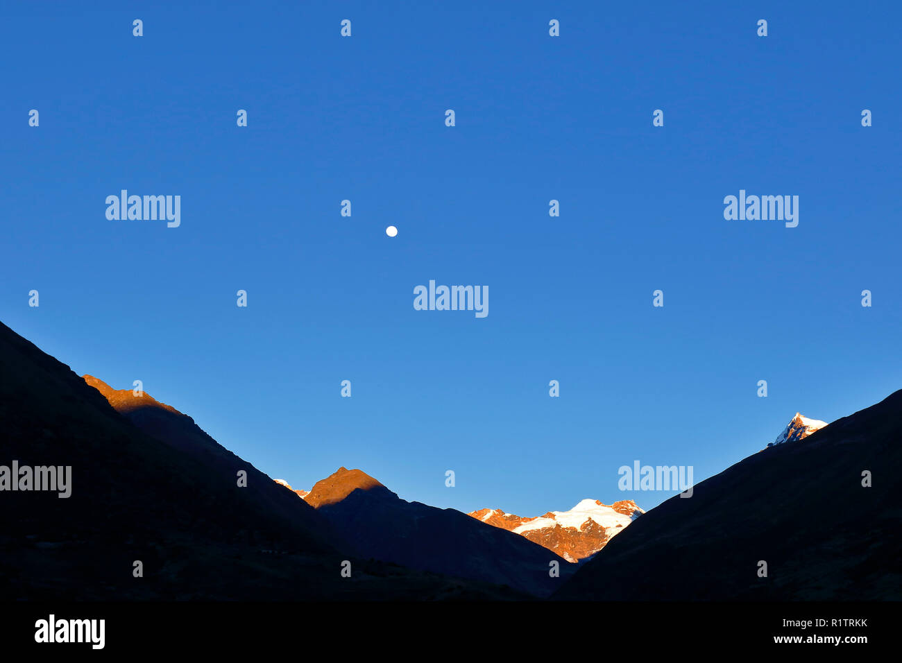 Beau lever de soleil vu dans les montagnes Huaytapallana à côté de la lune. Banque D'Images