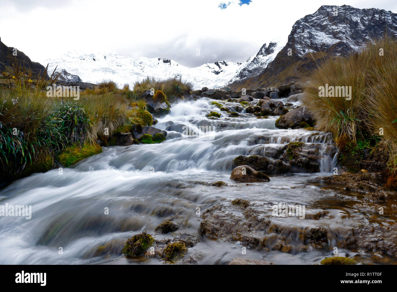 Vue sur un jour nuageux de la Snowy Huaytapallana à côté d'une petite rivière dans la cordillère centrale des Andes péruviennes Banque D'Images