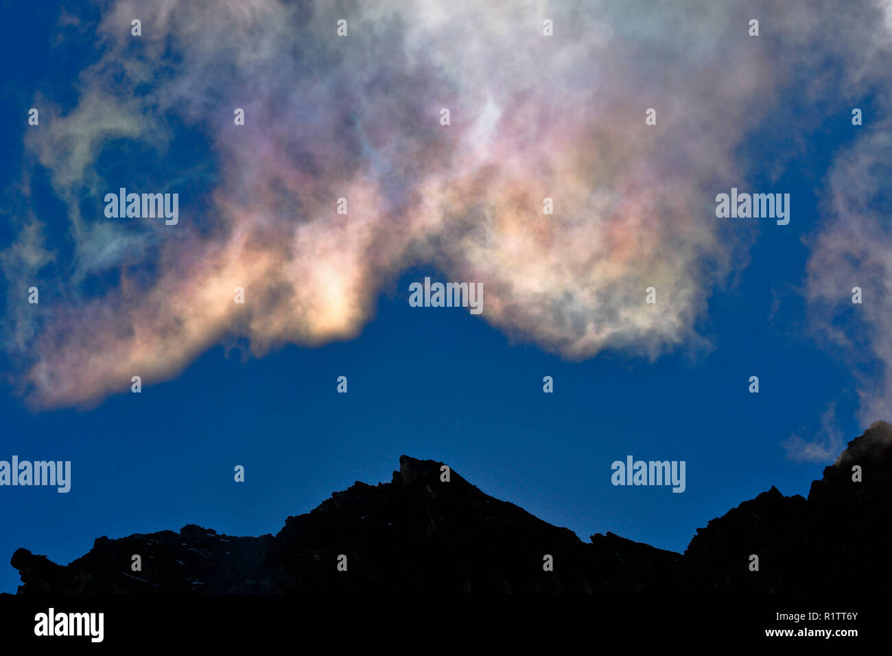 Un phénomène naturel appelé Nuages irisés, dans ce cas enregistré dans le matin avec la lumière du soleil émergeant de la roche dans le haut Ande Banque D'Images