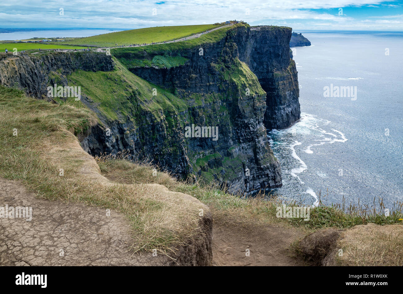 Les touristes marcher sur les falaises de Moher, le Burren, comté de Clare, Irlande Banque D'Images
