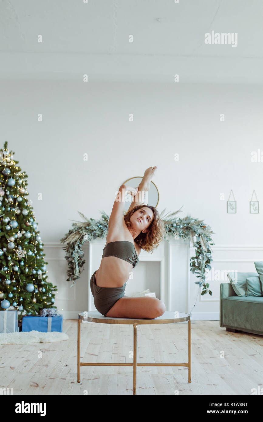 Attractive young woman working out contre mur gris, faisant du yoga, pilates exercice d'équilibre Banque D'Images
