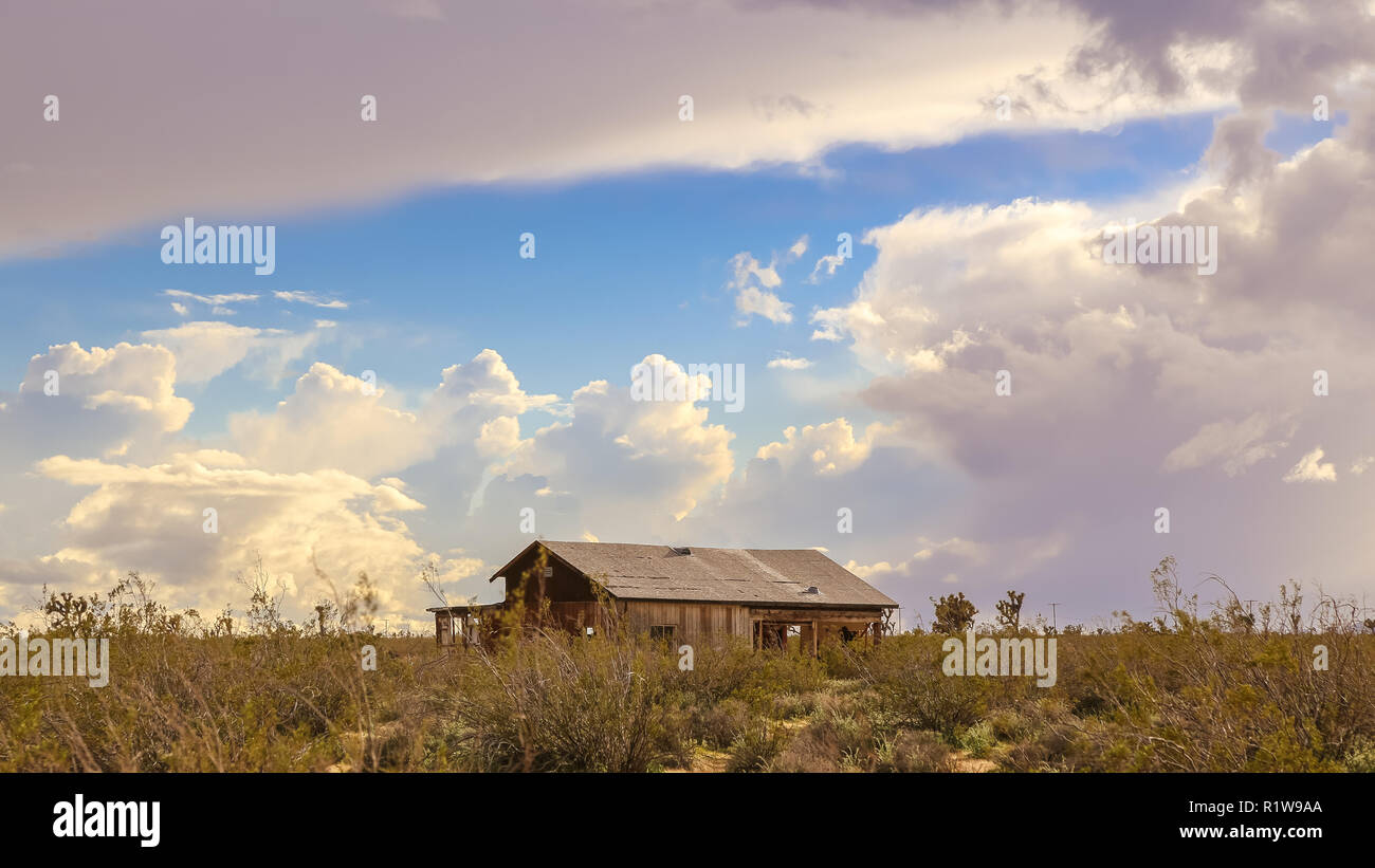 Seul bâtiment abandonné dans le désert de Mojave en Californie sous un ciel bleu et nuageux Banque D'Images