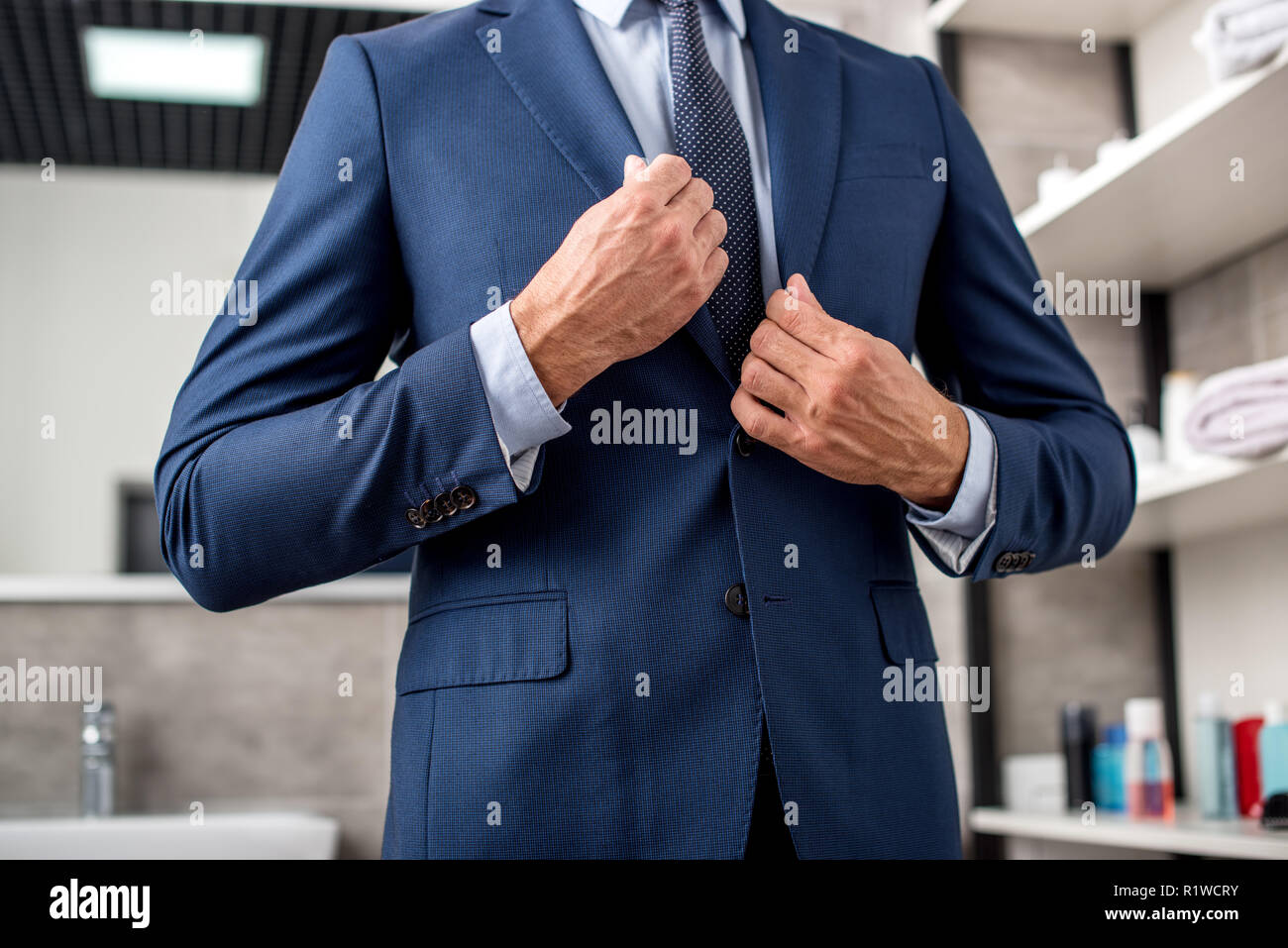 Cropped shot of businessman adjusting veste de costume dans la salle de bains Banque D'Images