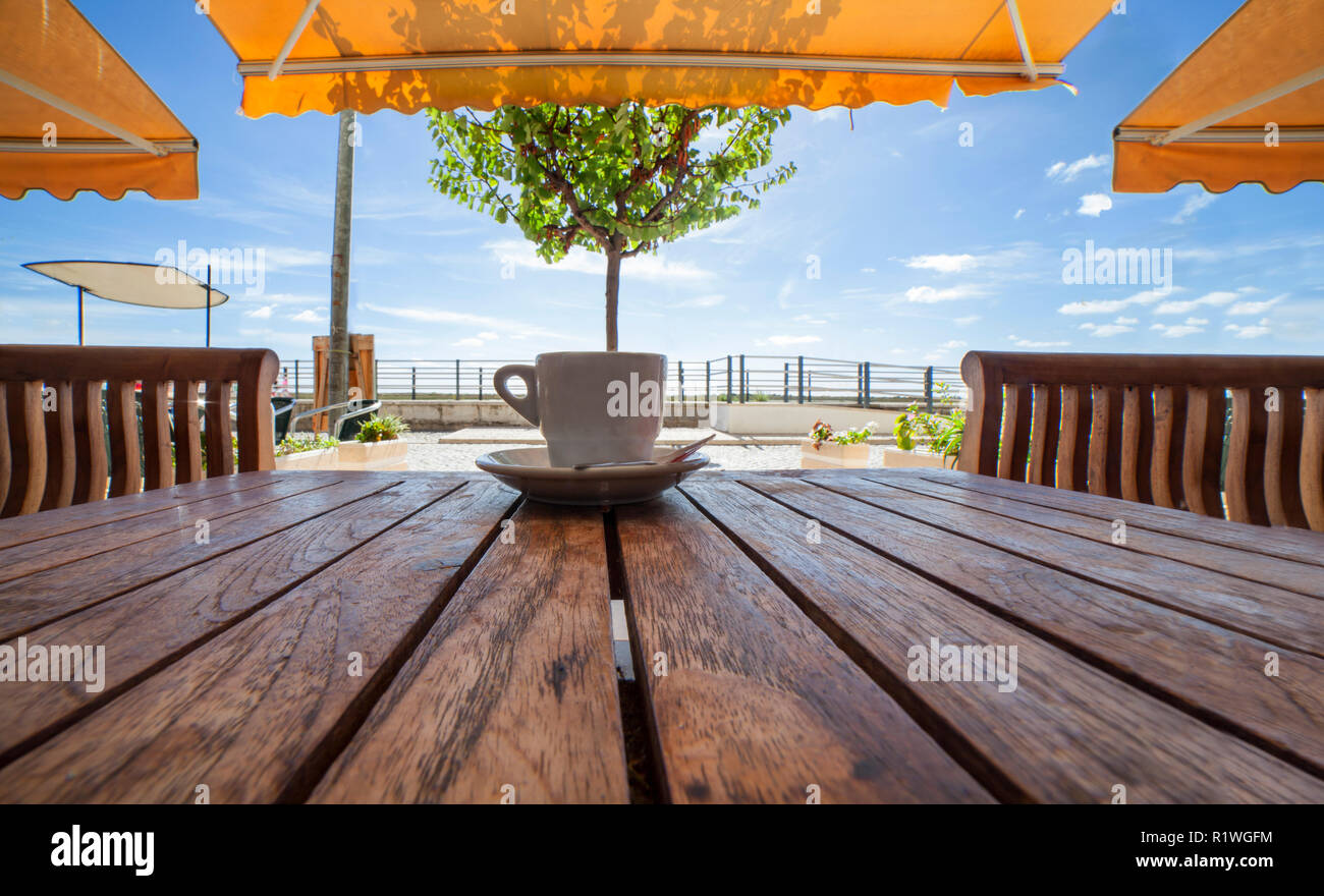 Cabanas de Tavira, Portugal - Octobre 14th, 2018 : La tasse de café espresso portugais bica ou sur table en bois. Détente à la terrasse de Cabanas de Tavira, Banque D'Images