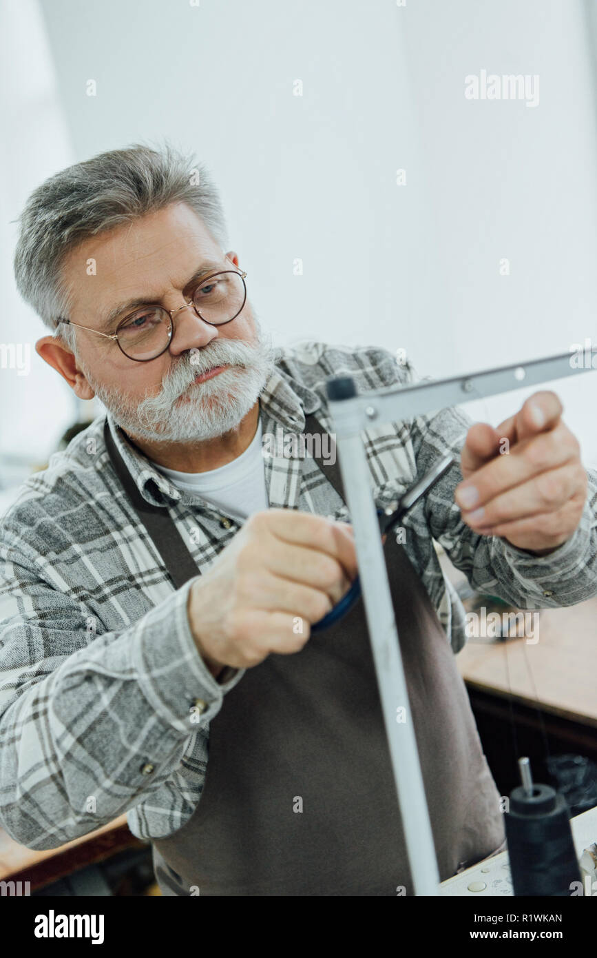 Âge moyen des hommes dans les chaînes de coupe sur mesure tablier sur machine à coudre à l'atelier Banque D'Images