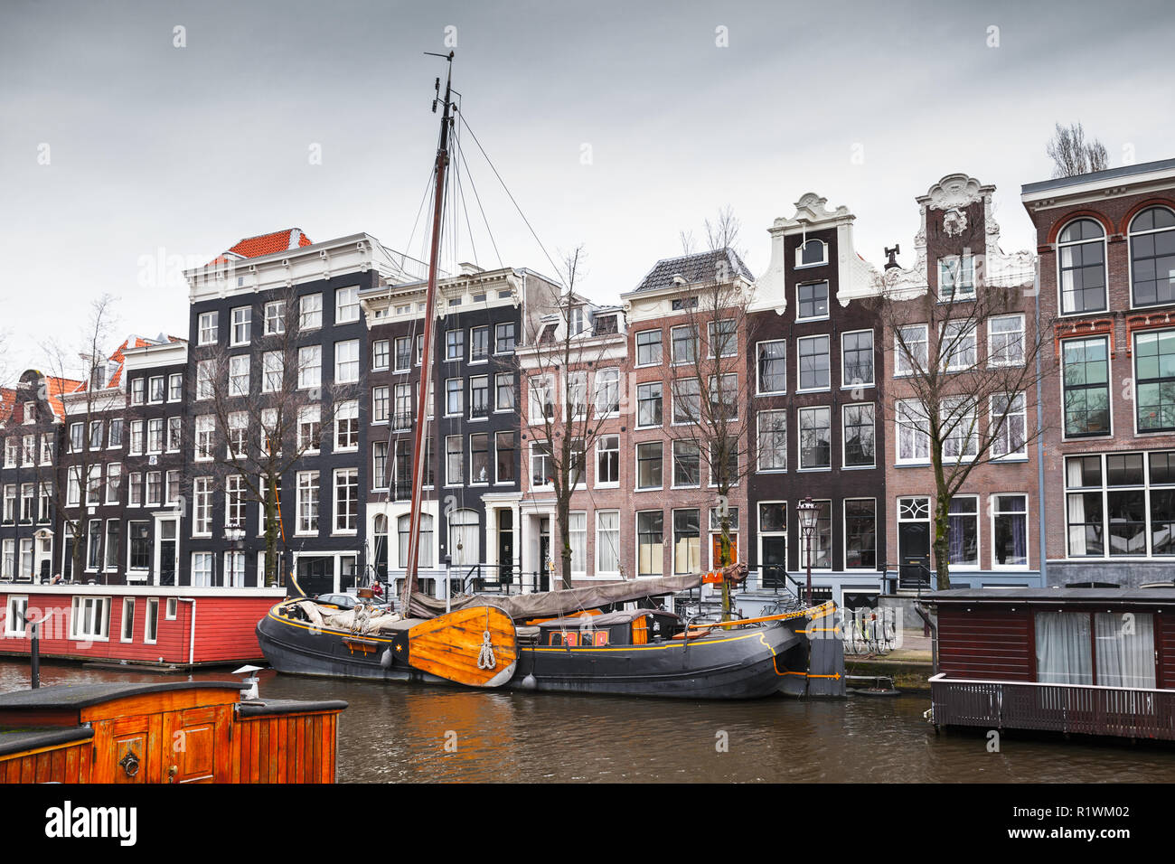 Maisons traditionnelles colorées et bateaux amarrés le long du canal à Amsterdam, Pays-Bas Banque D'Images