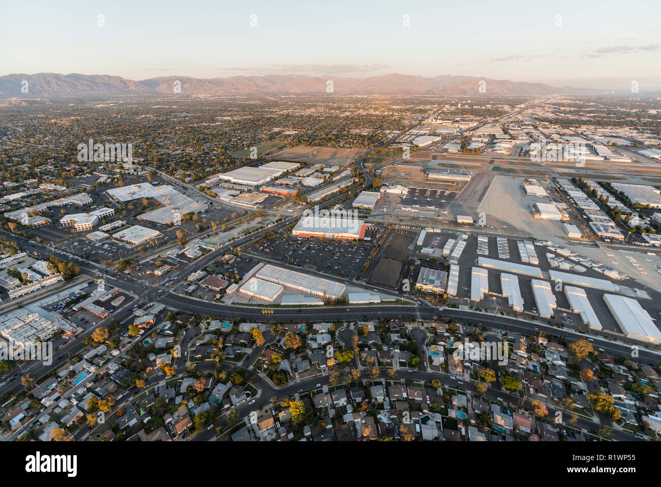 La fin de l'après-midi vue aérienne de maisons, bâtiments industriels, tarmac et piste à Van Nuys airport dans la vallée de San Fernando. Banque D'Images