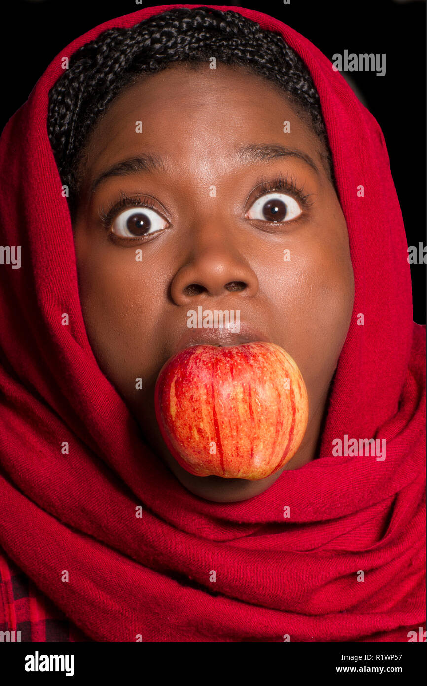 Femme avec apple en bouche Banque D'Images