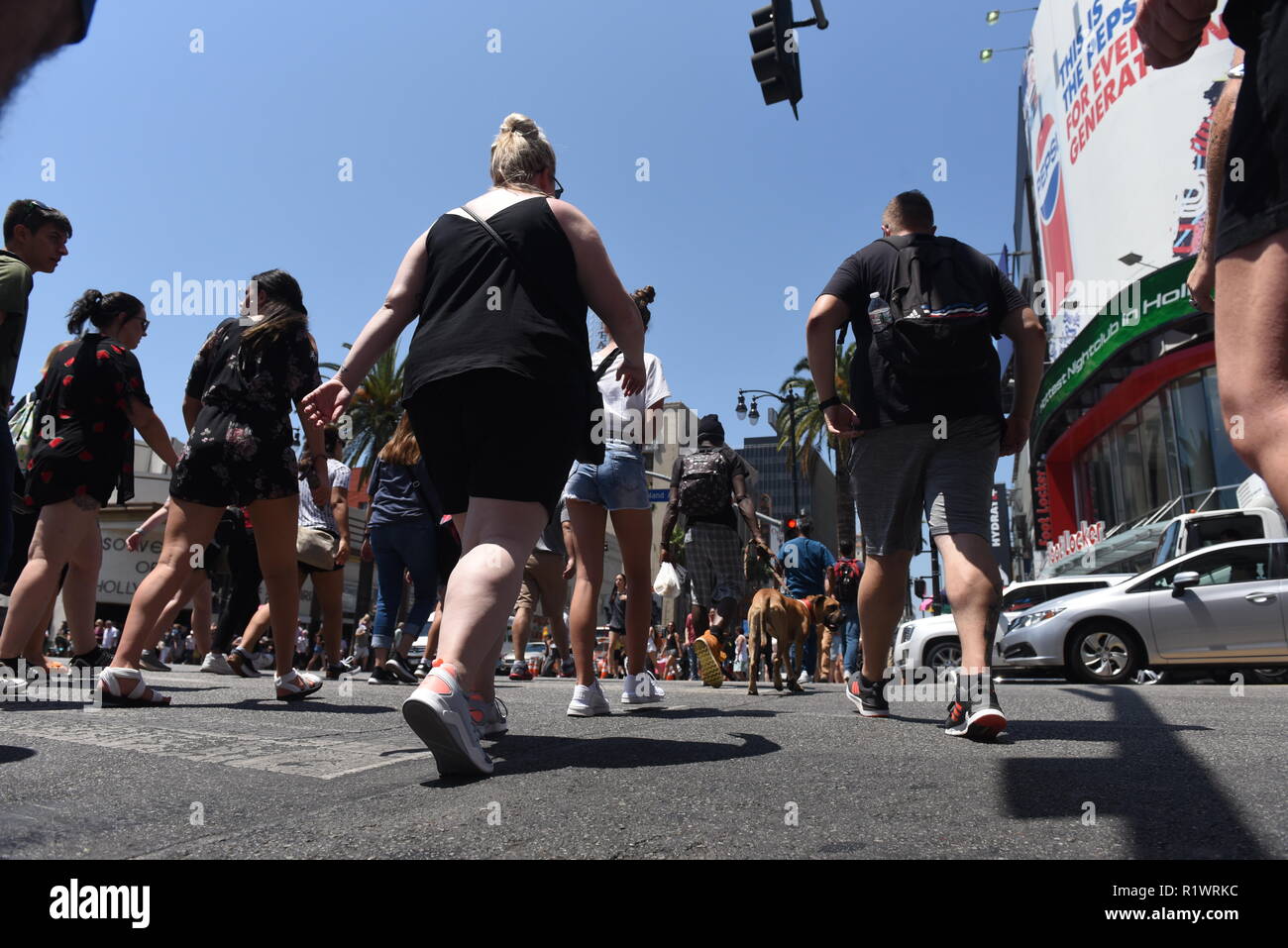 HOLLYWOOD - 7 août 2018 : Les personnes qui traversent la route à partir de l'angle faible point de vue sur Hollywood boulevard à Hollywood, CA. Banque D'Images
