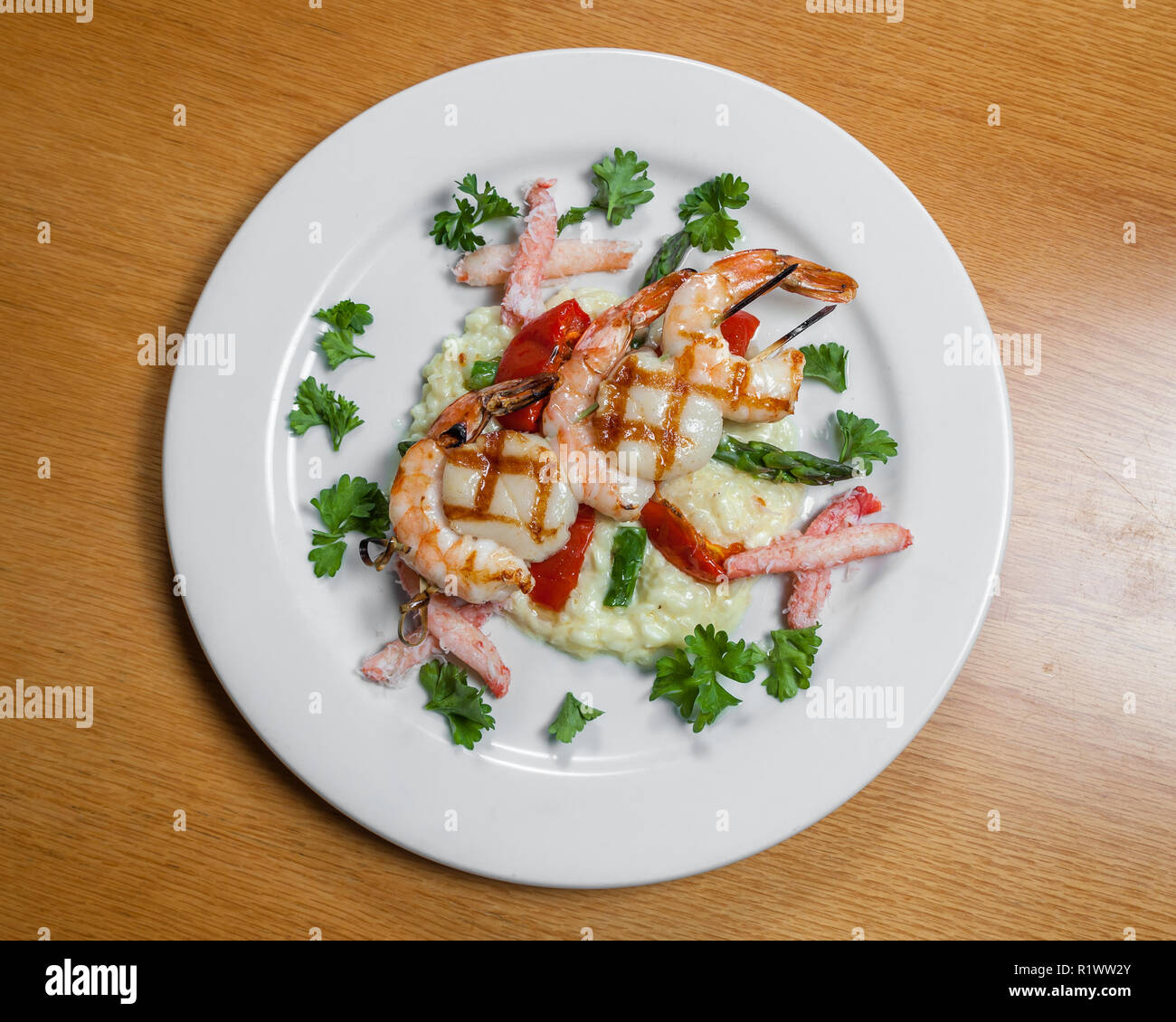 Gambas grillées et les pétoncles servis au sommet d'un crabe risotto crémeux Banque D'Images