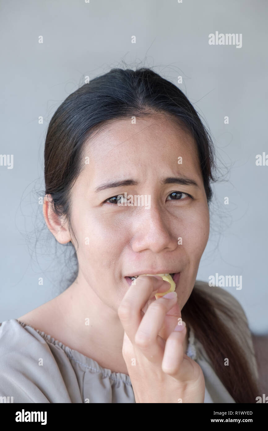 Les émotions de l'acide sur le cute asian woman face. Banque D'Images