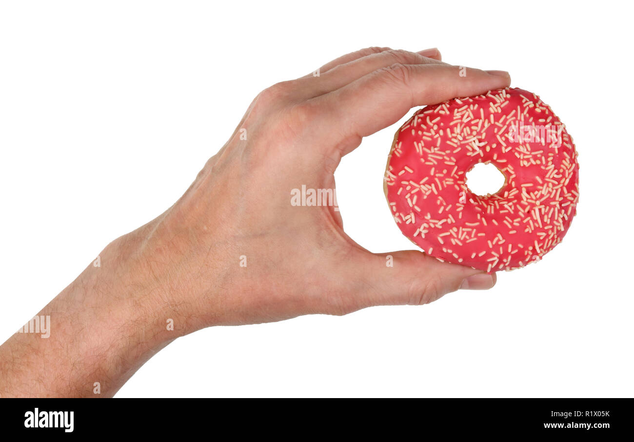 L'ancienne main de l'homme est titulaire d'un rose doux donut glaçage à la fraise. Gros plan studio isolated on white Banque D'Images