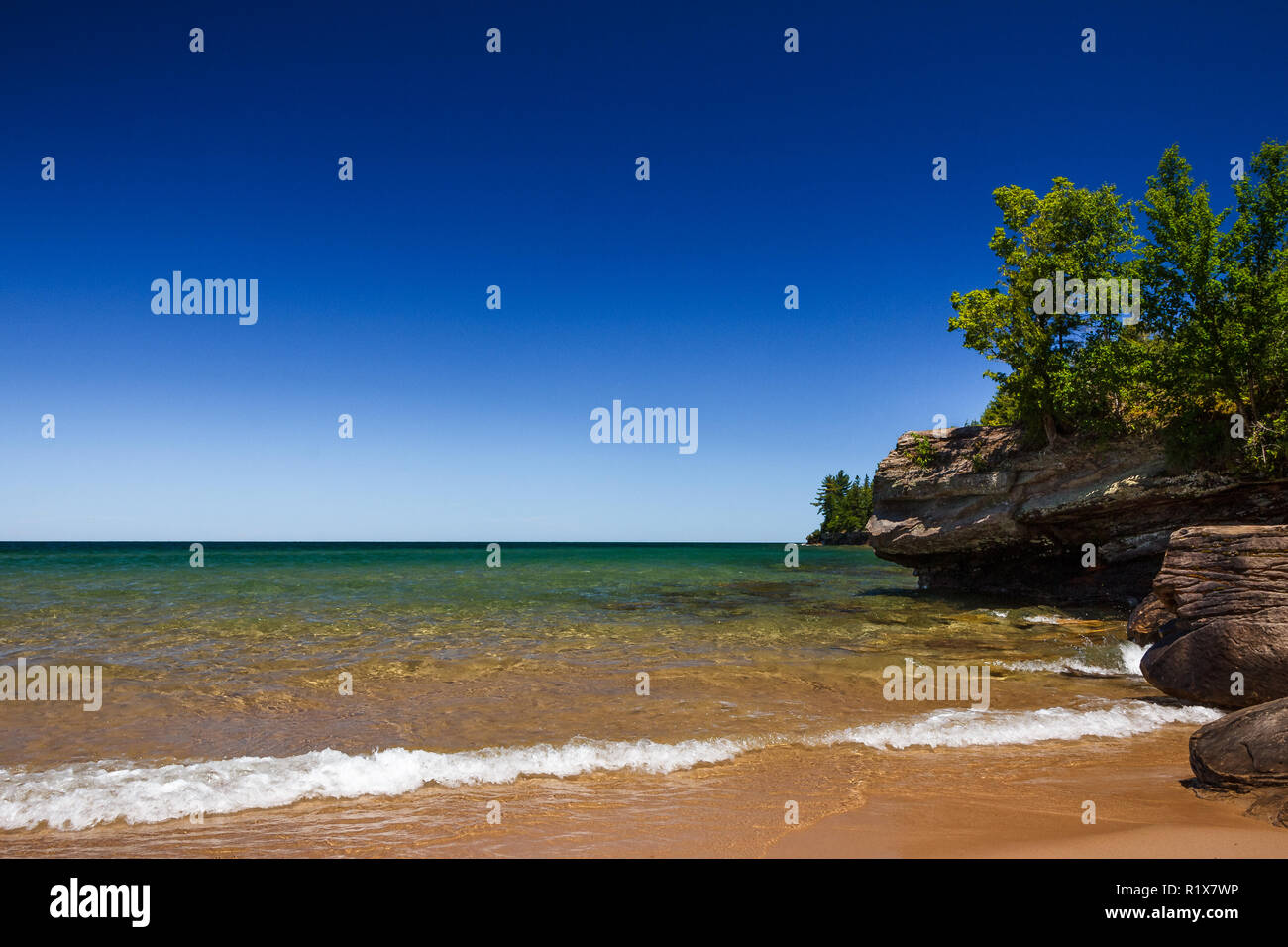 Ciel bleu clair à plage de sable avec des côtes rocheuses. Au-dessus de l'eau horizon historique avec l'exemplaire de l'espace. Banque D'Images