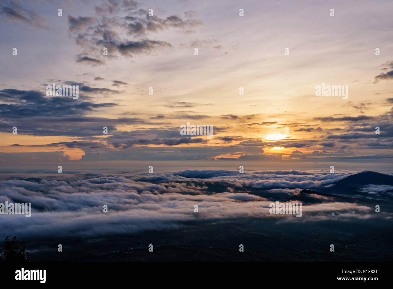 Belle nature paysage le soleil est au-dessus de la mer du brouillard qui couvre les montagnes et ciel lumineux pendant le lever du soleil dans l'hiver au point de vue de Phu Ruea Banque D'Images