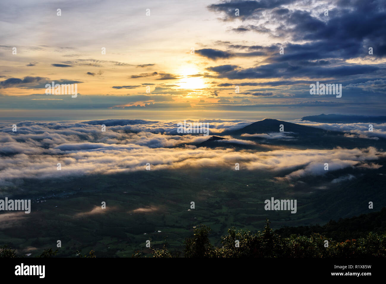 Belle nature paysage le soleil est au-dessus de la mer du brouillard qui couvre les montagnes et ciel lumineux pendant le lever du soleil dans l'hiver au point de vue de Phu Ruea Banque D'Images