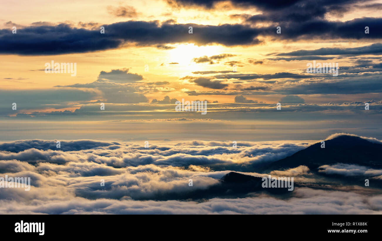 Belle nature paysage le soleil est au-dessus de la mer du brouillard qui couvre les montagnes et ciel lumineux pendant le lever du soleil dans l'hiver au point de vue de Phu Ruea Banque D'Images