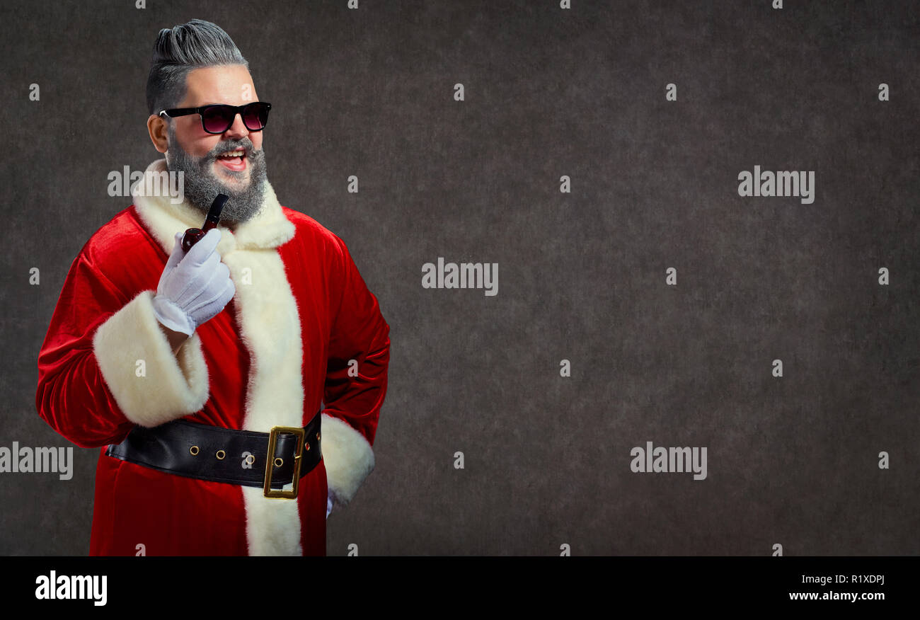 Père Noël avec une coiffure et une fumée de cigare lance un joyeux Banque D'Images