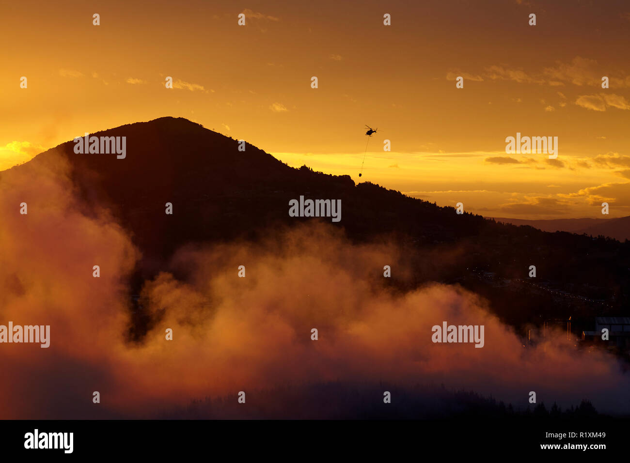Smokey sunset et combattre le feu de l'hélicoptère à Burnside, Dunedin, île du Sud, Nouvelle-Zélande Banque D'Images