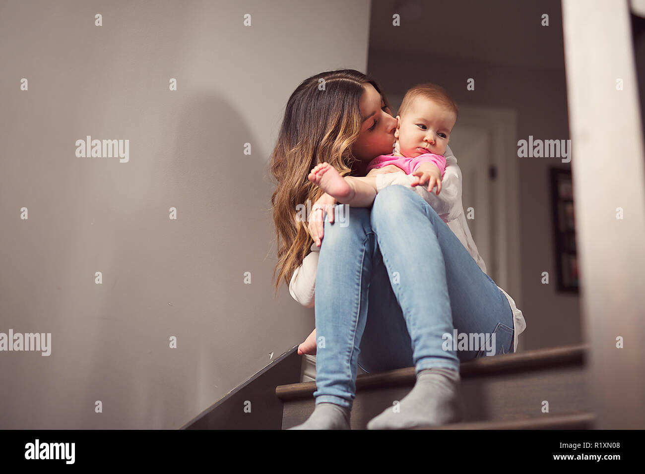 Une jeune mère avec un enfant assis sur les escaliers, chambre Banque D'Images