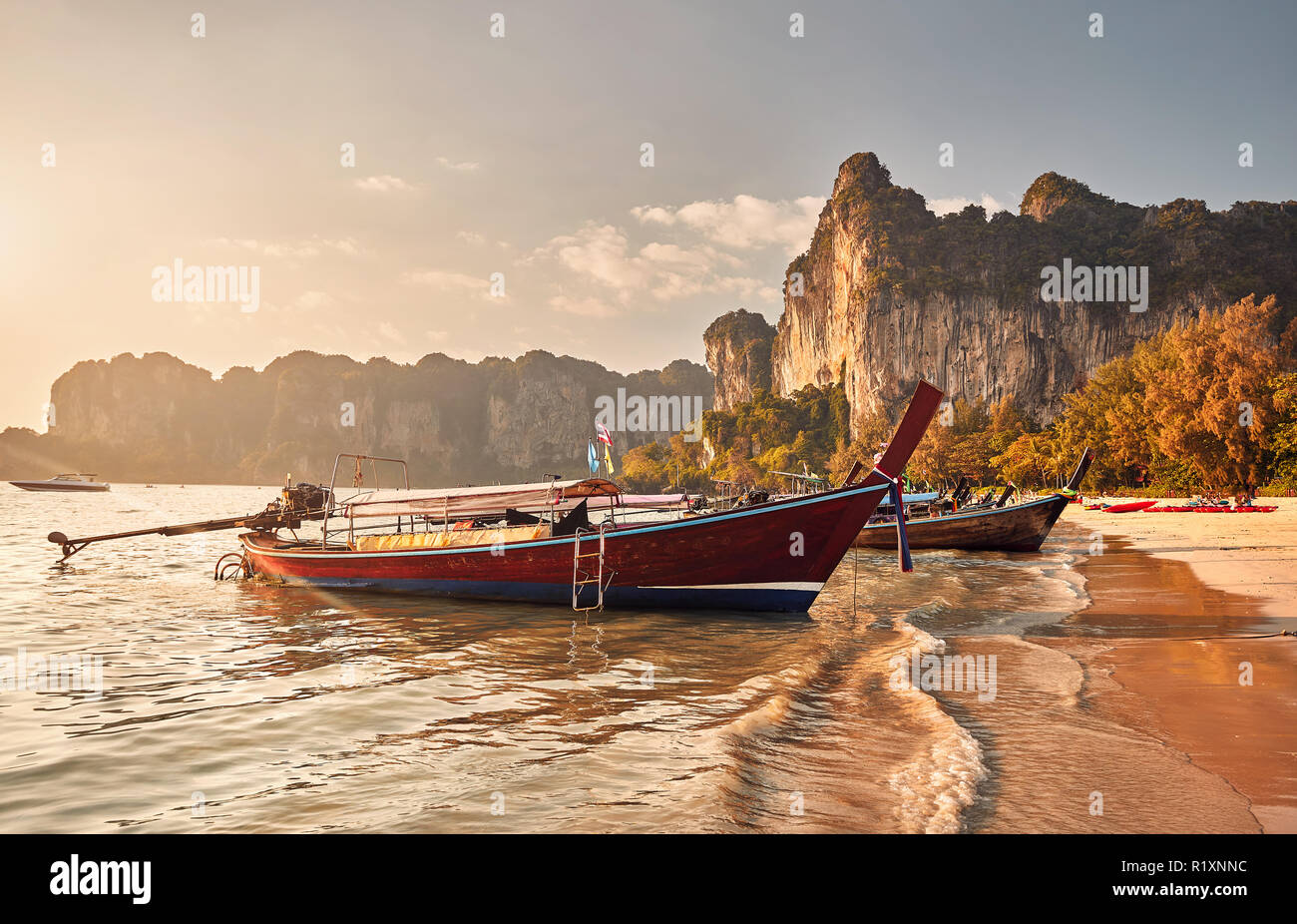Long Tail boats on tropical beach at beau coucher de Krabi, Thaïlande Banque D'Images