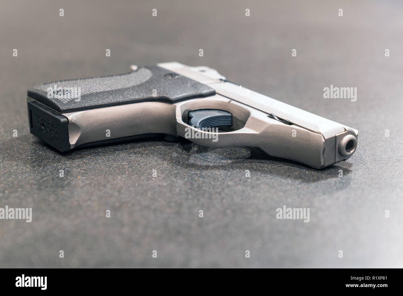 Pistolet semi-automatique d'argent isolé sur tableau noir Banque D'Images