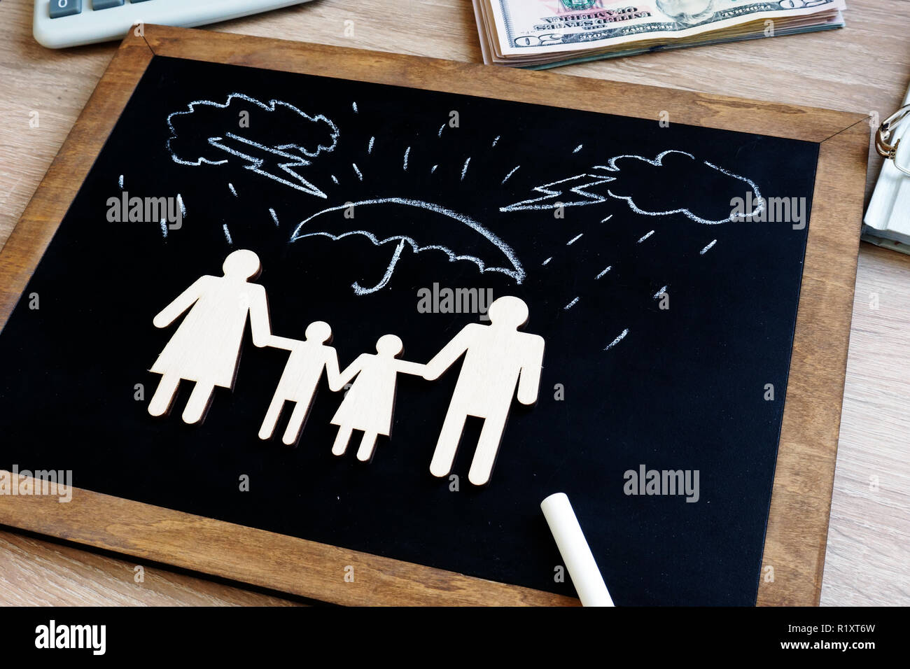 La santé et l'assurance-vie. Tableau noir avec chiffres de la famille dans l'agence. Banque D'Images