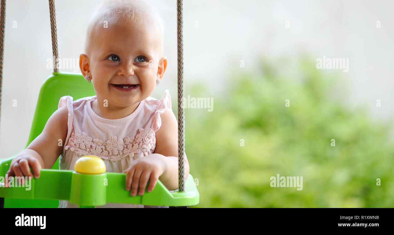 Happy cheerful baby smiling while on swing Banque D'Images