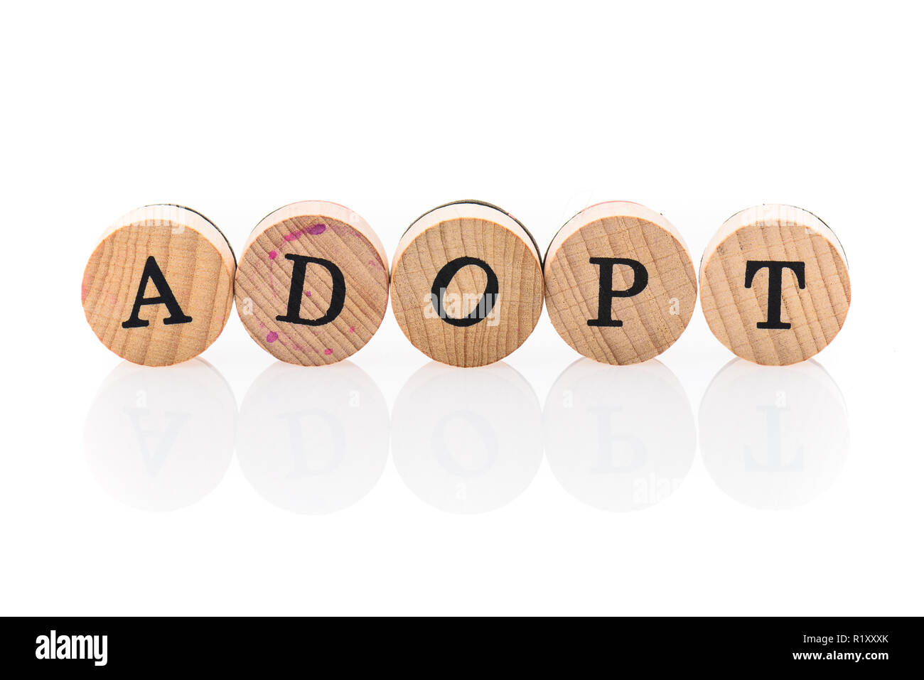 Mot Adopter à partir de tuiles en bois circulaire avec des lettres d'enfants jouet. Notion d'adoption écrit en lettres jouet pour enfants. Banque D'Images