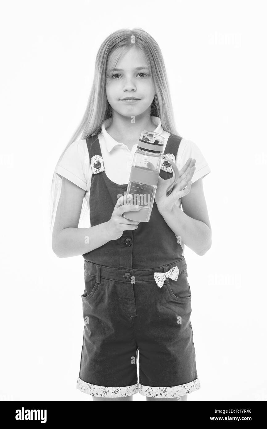 Petite fille avec bouteille en plastique isolé sur blanc. Soif enfant en pyjama rose Maintenez la bouteille d'eau. L'eau potable pour la santé. La soif et la déshydratation. L'activité de la petite enfance et de l'énergie. Banque D'Images