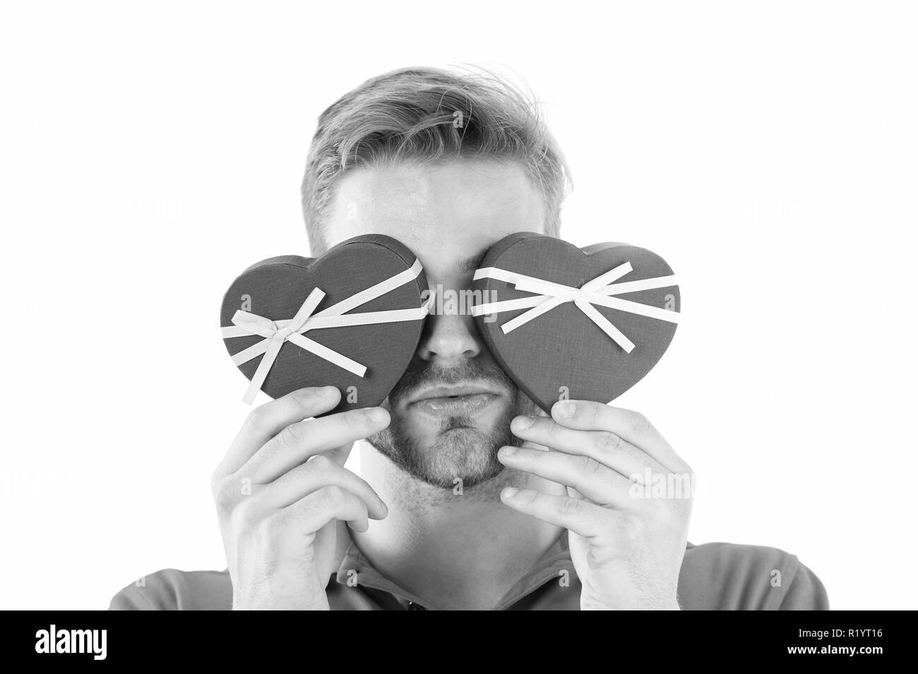 Devinez lequel. L'homme tient deux cadeaux en forme de coeur devant les yeux, fond blanc. Surprise romantique préparé macho pour la Saint-Valentin. Cadeaux de Jour de Valentines. Surprise romantique pour elle. Banque D'Images