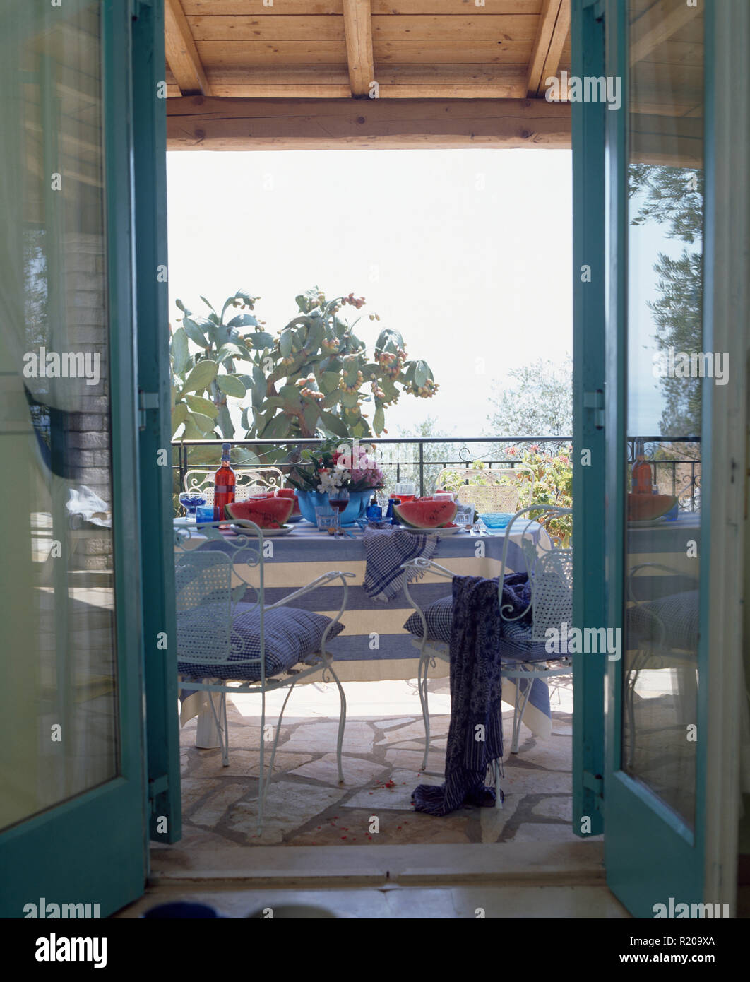 Les portes en verre s'ouvrent à la côte de la terrasse avec set de table pour le déjeuner Banque D'Images