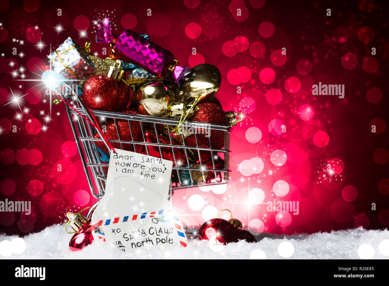 Concept d'achats de Noël, un panier plein de cadeau et une lettre au Père  Noël la décoration, sur la neige, contre un magnifique arrière-plan  bokelicious rouge Photo Stock - Alamy