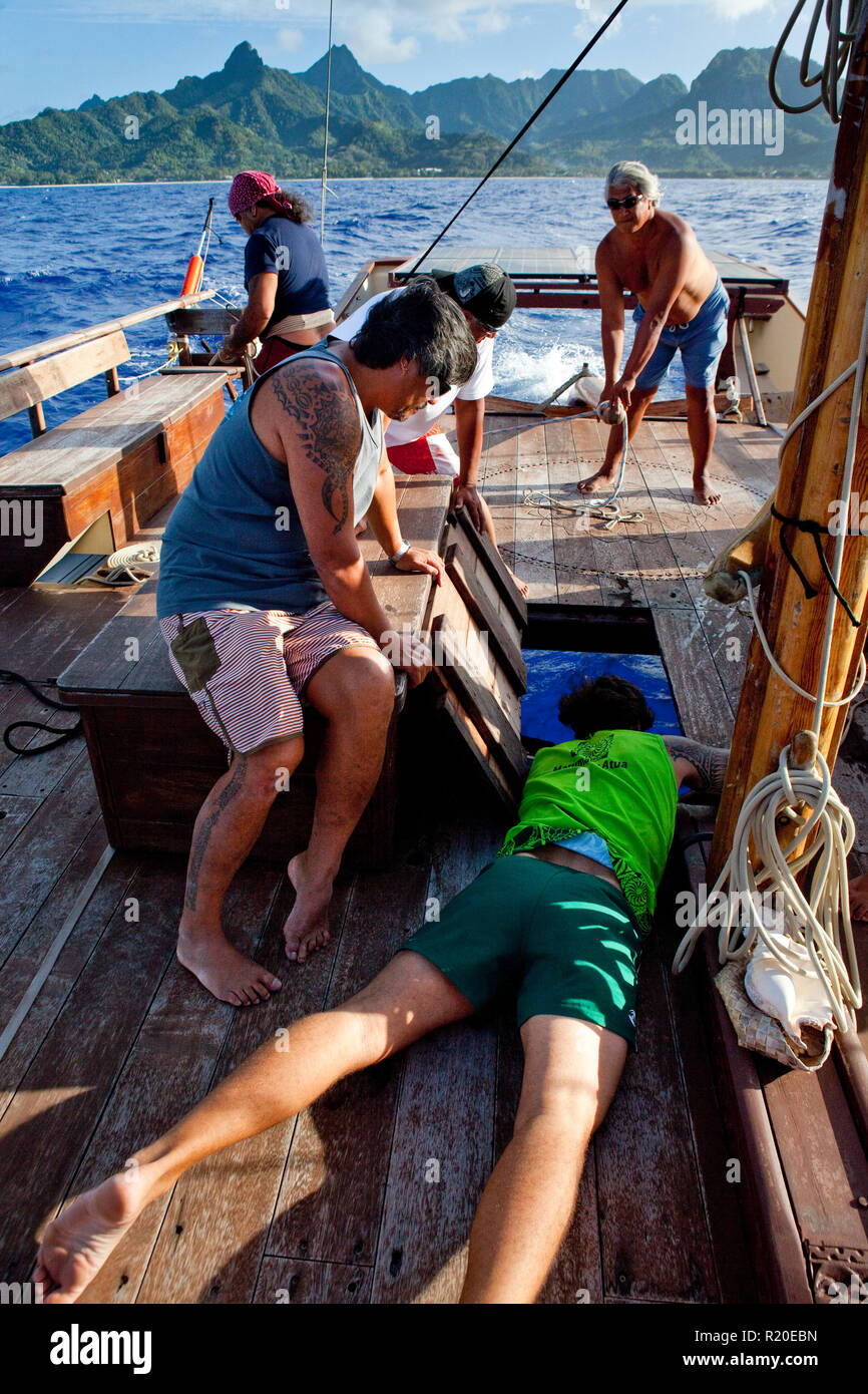Au travail de l'équipage à bord du Marumaru Atua, une moderne de 22 mètres "vaka" construit dans le style traditionnel polynésien de trans-océanique voyageant des navires. Banque D'Images